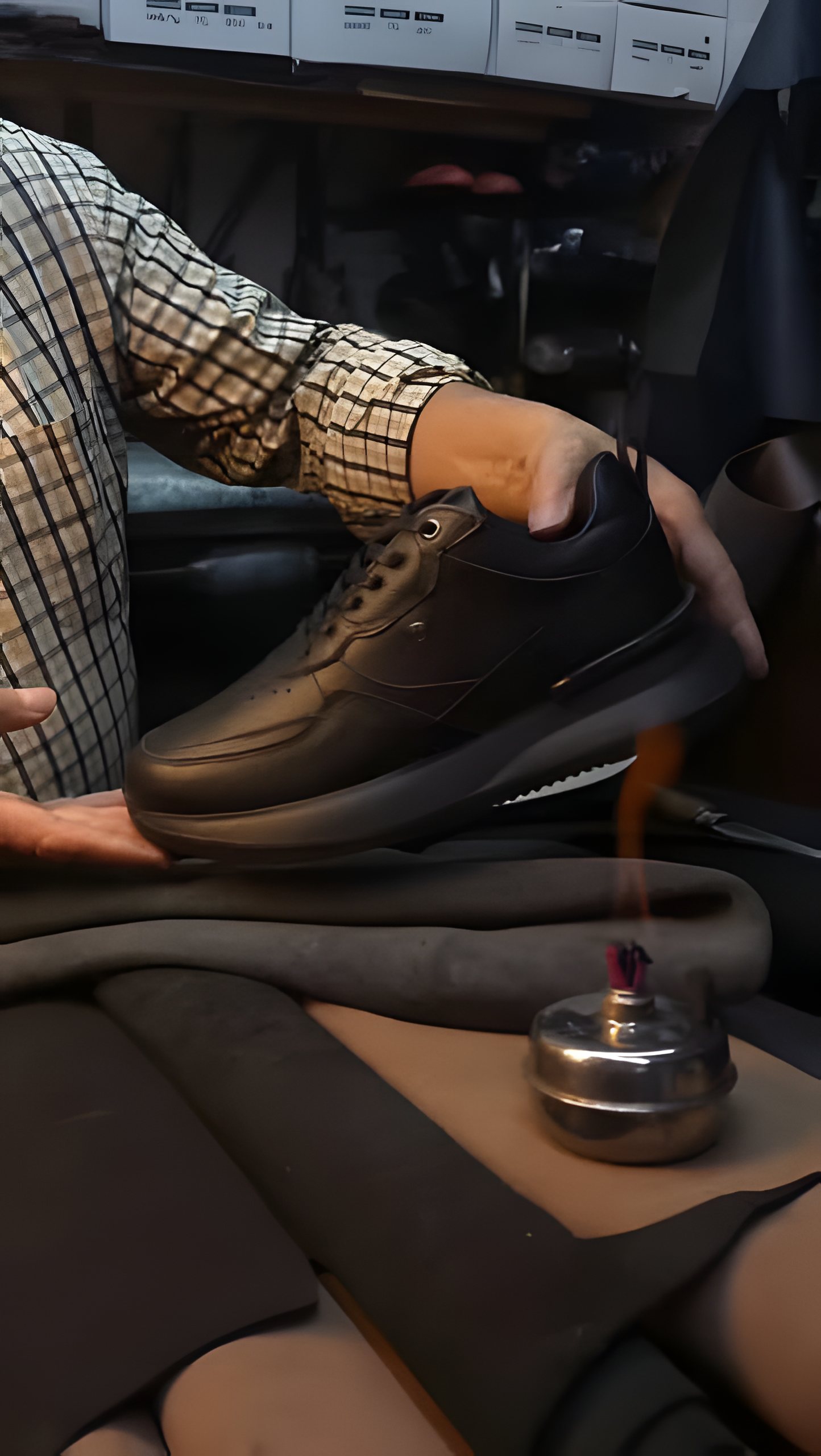 Zapato de cuero negro en el taller con herramientas